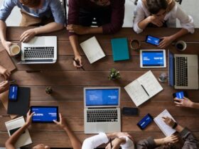 Emprendedores reunidos con portátiles en mesa de madera