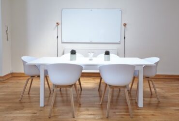 Mesa blanca con sillas sobre suelo de madera