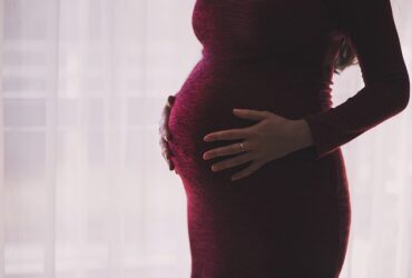 Mujer embarazada con vestido granate